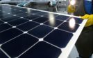 An employee of SunPower Corp. trims the edges and checks solar panels at the SunPower Corp. module manufacturing plant at Flextronics in Milpitas, California, U.S., on Wednesday, Aug. 24, 2011.