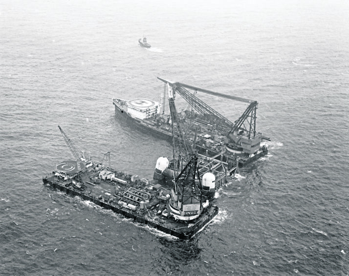 The 23,000-ton steel jacket Highland One is secured to the seabed on the Forties Field by the giant crane barges Hercules and Thor in 1974.