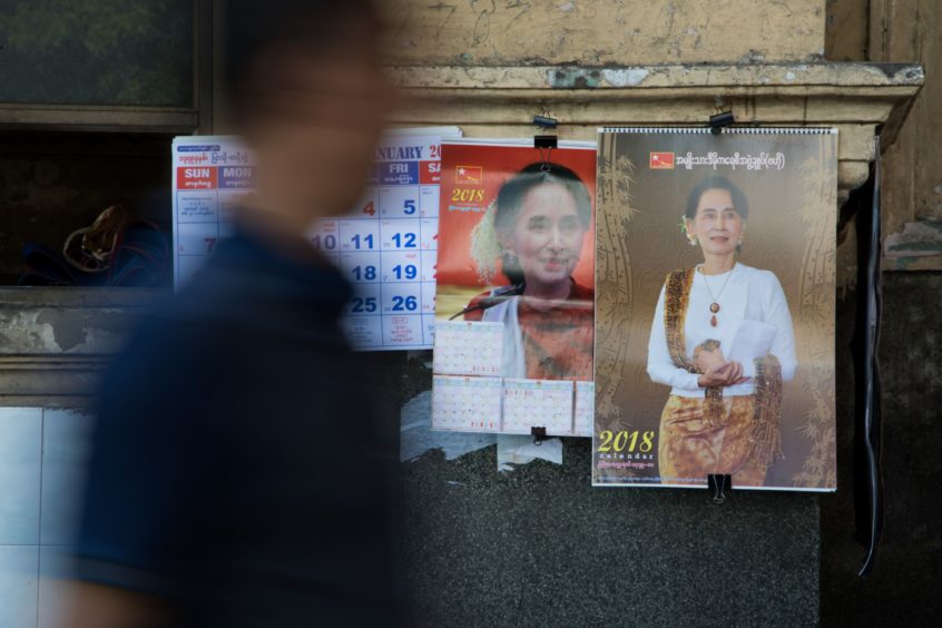 A man walks past calendars featuring images of Myanmar leader Aung San Suu Kyi in Yangon, Myanmar, on Monday, Dec. 18, 2017. Photographer: SeongJoon Cho/Bloomberg