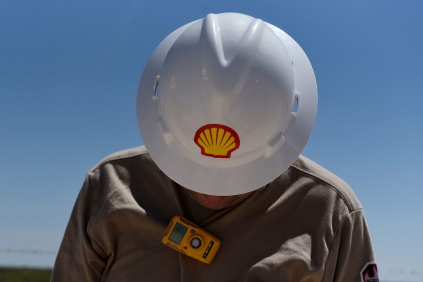 A logo is displayed on the hardhat of a worker at the Royal Dutch Shell Plc processing facility in Loving, Texas, U.S., on Friday, Aug. 24, 2018.