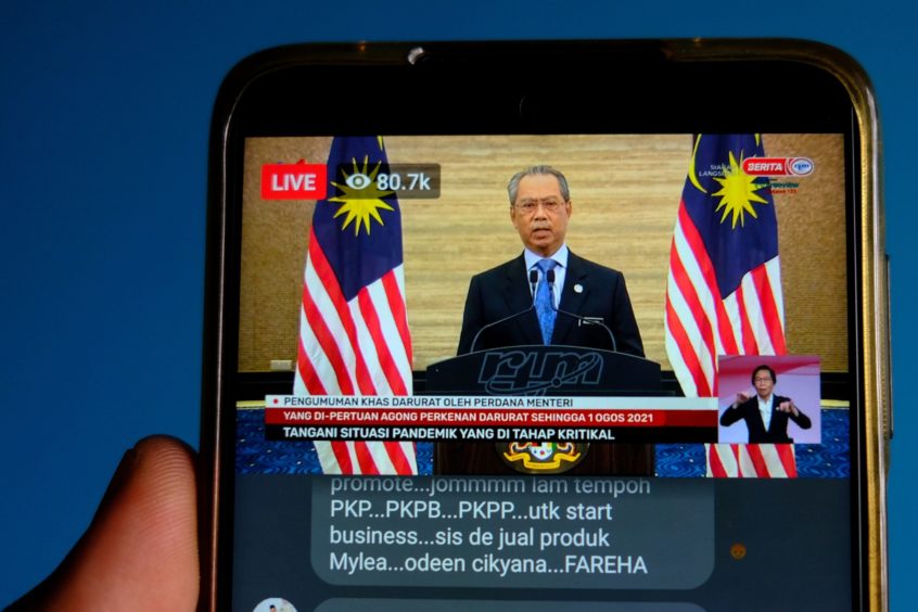 A live news broadcast of Malaysia's Prime Minister Muhyiddin Yassin, is arranged on a smartphone in Shah Alam, Selangor, Malaysia, on Tuesday, Jan. 12, 2021.