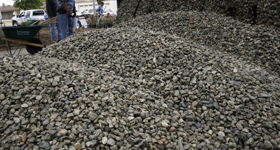 Gravel pours from a dump truck as landscapers with Turf Terminators remove the front grass lawn of a home to replace it with drought-friendly landscaping in Chatsworth, California, U.S., on Tuesday, April 21, 2015. As California's water shortage grows more severe and local governments enact increasingly stringent conservation policies, homeowners across the state are reimagining their lawns. Photographer: Patrick T. Fallon/Bloomberg