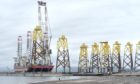 The large floating crane barge, Seajacks Scylla loads wind turbine base platforms at Nigg Energy Park for the Moray East offshore wind farm