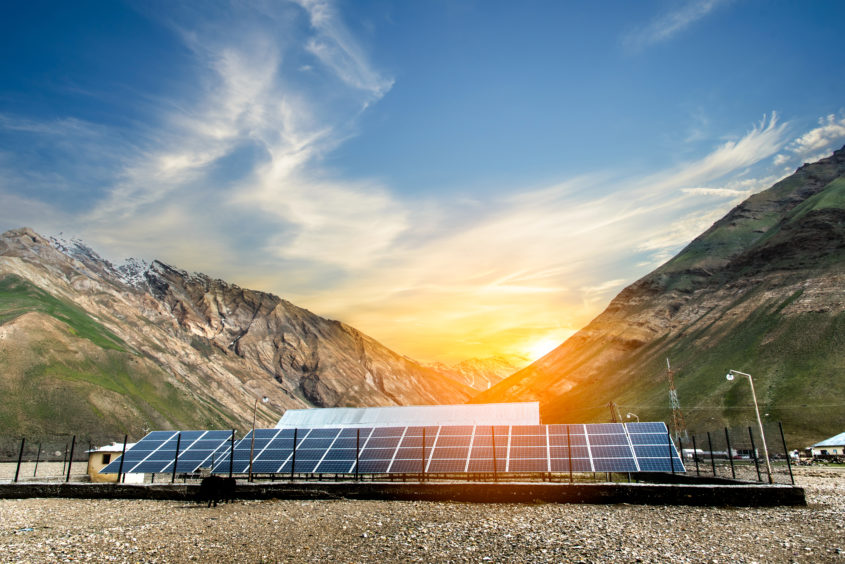 Power plant using renewable solar energy with sunset over the Gap in the Himalayan Mountain, Kashmir, India