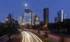 Night time with car light trails and skyscrapers