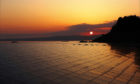 Solar panels with sun setting behind