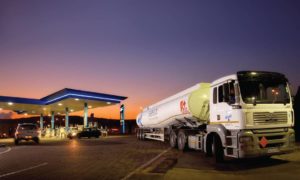 A Sasol fuel tanker leaves a fuel station at dusk