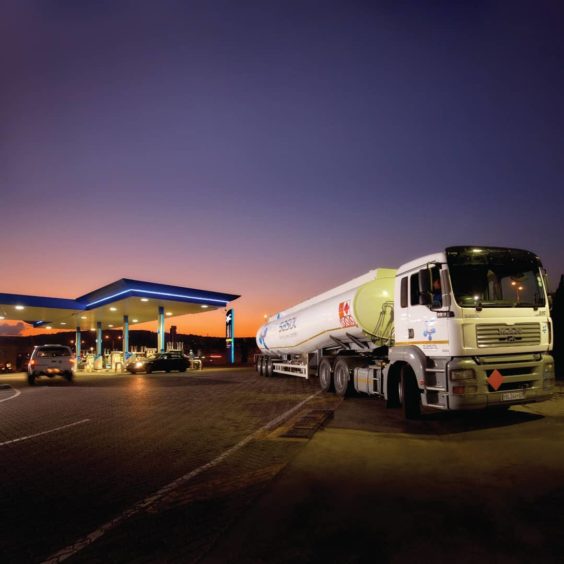 A Sasol fuel tanker leaves a fuel station at dusk