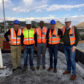 Group of men in high vis jackets on site