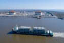 A ship carrying LNG equipment moves along a waterway