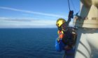 A PD&MS rope access technician working at a wind farm