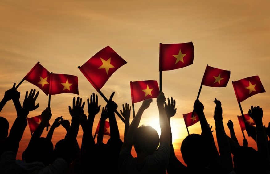 A group of people waving Vietnamese flags.