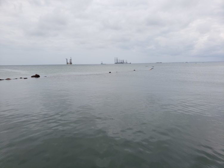 Platforms on the horizon, with water in the foreground