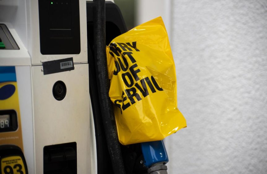 An empty pump at a gas station is covered with a yellow plastic bag following a cyber attack on the Colonial Pipeline.