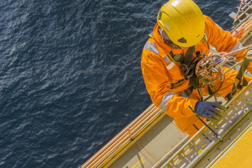 Oil worker climbs ladder offshore