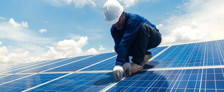 Man in hard hat stands on solar panel