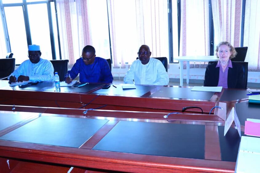 Three men and a woman sit at a conference table