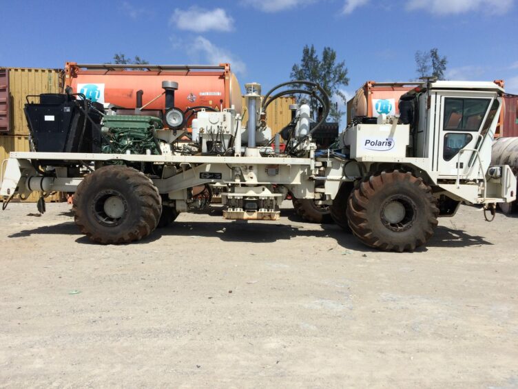 A vibroseis truck on a dirt road in sunshine