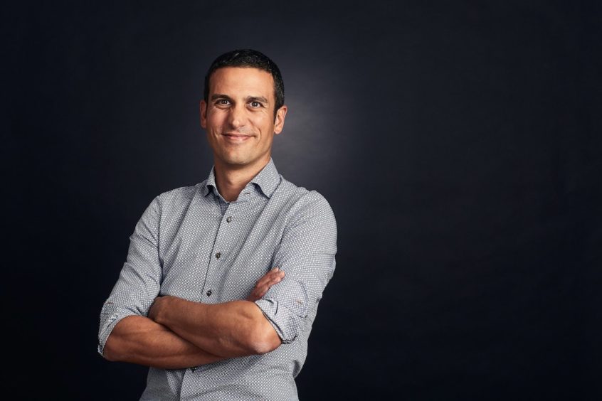 Headshot of a man against a grey background