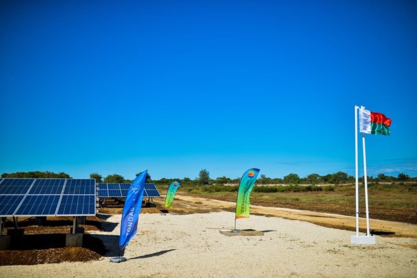 Solar panels on the left, flags on the rights under a blue sky