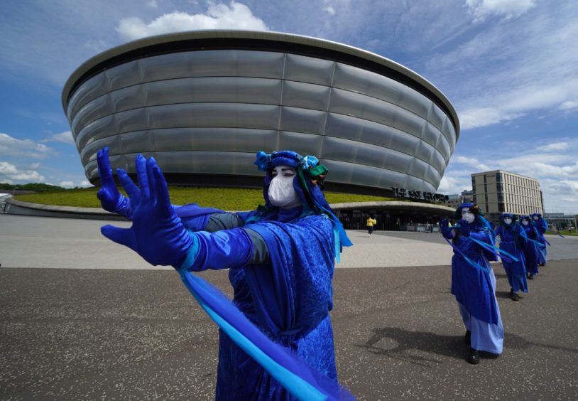 Extinction Rebellion Scotland's Blue Rebels perform outside the SEC Armadillo in Glasgow, where the global climate change conference Cop26 will take place in November: Andrew Milligan/PA Wire