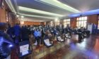 People attend a presentation with a row of empty seats in front