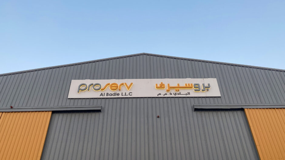 A warehouse with a sign in English and Arabic