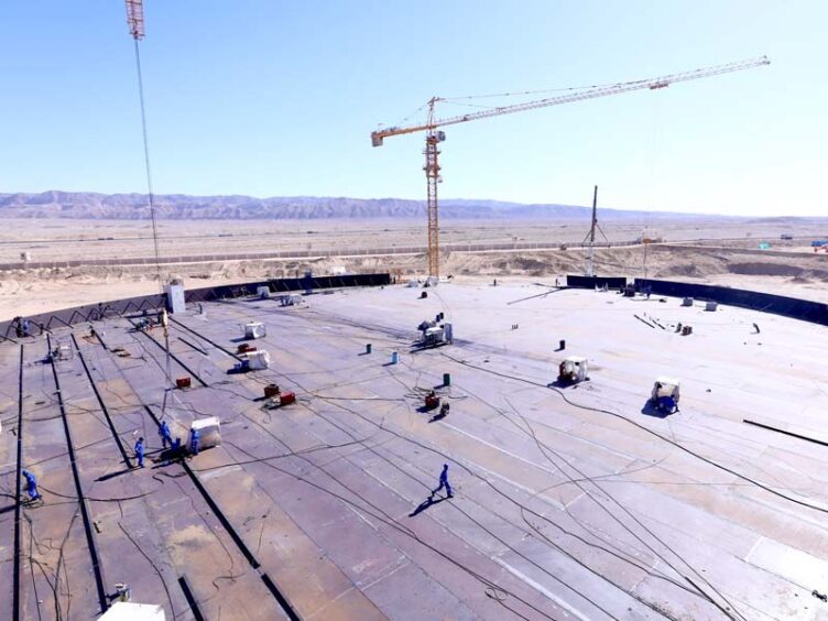 Aerial shot of men and cranes at an oil storage site