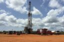 Drilling rig against blue sky with white clouds