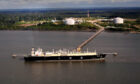 An LNG carrier docked at the end of a long jetty