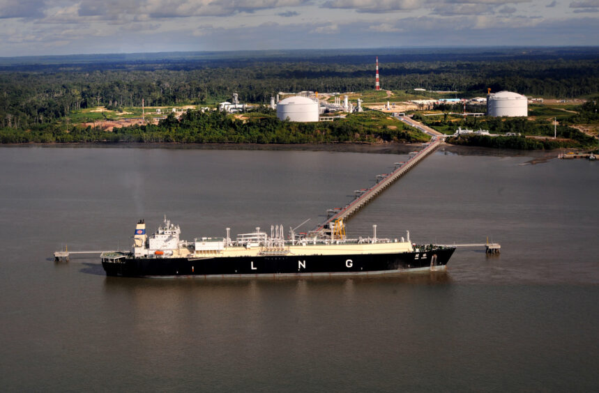 An LNG carrier docked at the end of a long jetty