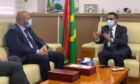 Two men sit on sofas and talk