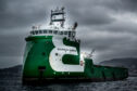A green ship under dark clouds