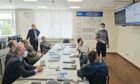 Men sit around a table talking about Gazprom things