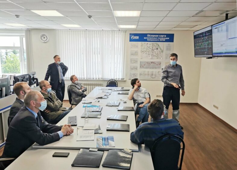 Men sit around a table talking about Gazprom things