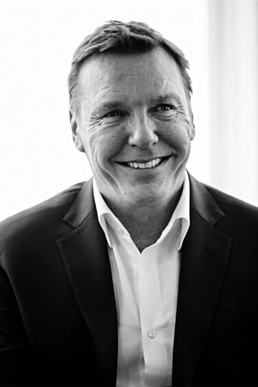 Black and white headshot of man with no tie