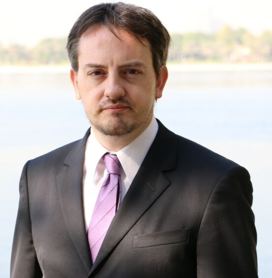 Headshot of man with pink tie