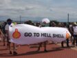 People carry a "go to hell Shell" banner