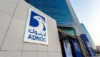 Blue Adnoc logo on a building outside an office