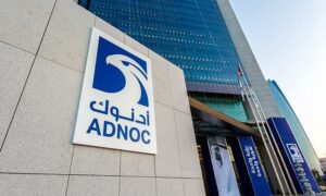 Blue Adnoc logo on a building outside an office