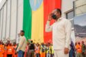 Man salutes in front of big Ethiopian flag