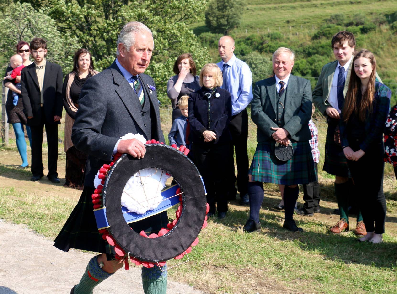 The Prince of Wales lays a wreath during a visit to Cabrach Cairn