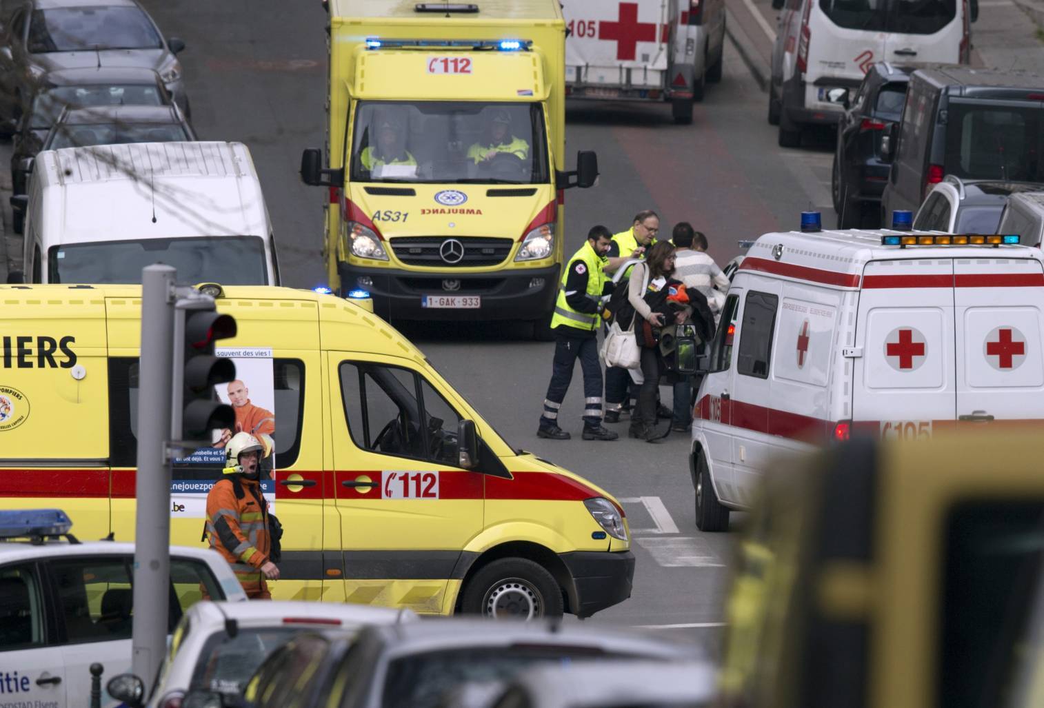 A woman is evacuated by emergency services after a explosion in a main metro station in Brussels