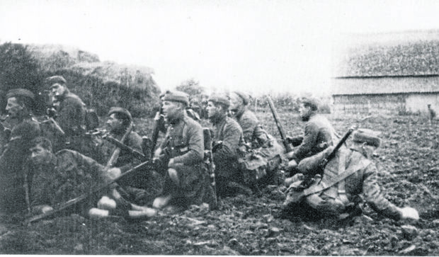 Gordon Highlanders wait on the edge of a field near Ypres