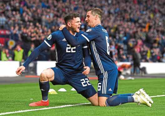 Scotland's Oliver Burke celebrates his late goal earlier this year with Kenny McLean, right.