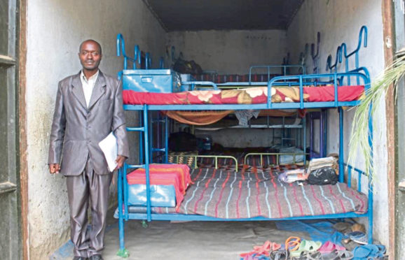 Little Angels School head teacher Kenneth Turyasingura beside the children’s current sleeping facilities