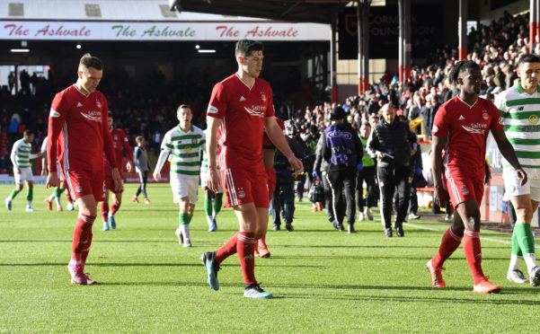 Aberdeen trudge off after a dismal first half against Celtic.
