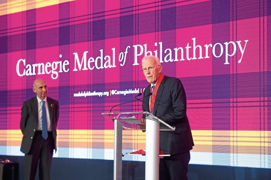 Sir Ian Wood picks up the Carnegie Medal of Philanthropy at a ceremony in New York