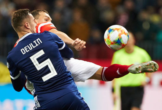 Artem Dzyuba of Russia and Michael Devlin of Scotland.