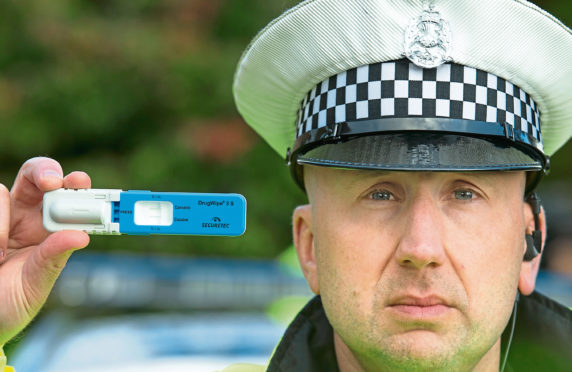 PC Stewart Logan holding one of the DrugWipe testing kits that are already being utilised by officers